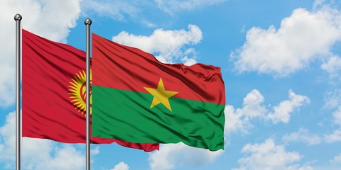 Kyrgyzstan and Burkina Faso flag waving in the wind against white cloudy blue sky together. Diplomacy concept, international relations.