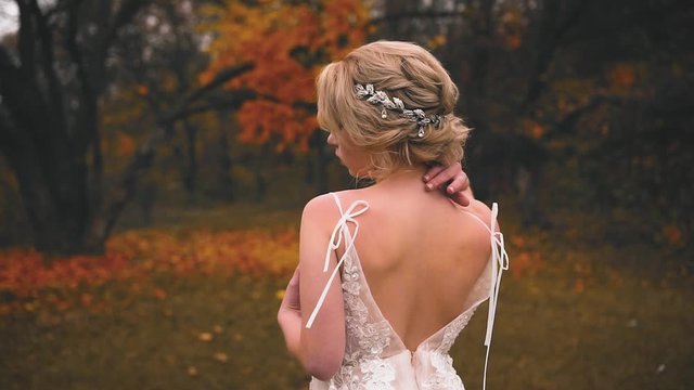 Beauty fashionable elegant collected high hairstyle. blonde woman enjoys autumn nature. Vintage silver diadem on hair. Seductive dress with open back. Mysterious queen without a face. sexy rear view
