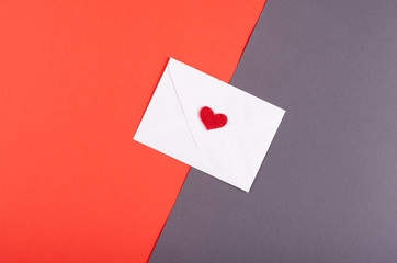 Paper envelope with red heart composition on red background.