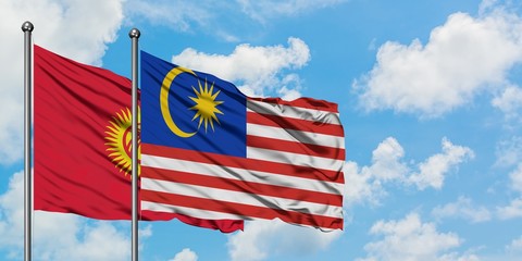 Kyrgyzstan and Malaysia flag waving in the wind against white cloudy blue sky together. Diplomacy concept, international relations.