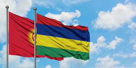 Kyrgyzstan and Mauritius flag waving in the wind against white cloudy blue sky together. Diplomacy concept, international relations.