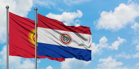 Kyrgyzstan and Paraguay flag waving in the wind against white cloudy blue sky together. Diplomacy concept, international relations.