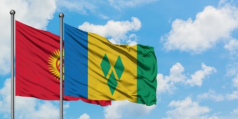Kyrgyzstan and Saint Vincent And The Grenadines flag waving in the wind against white cloudy blue sky together. Diplomacy concept, international relations.