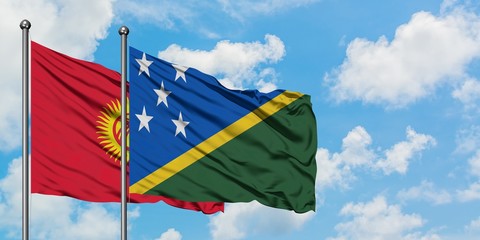 Kyrgyzstan and Solomon Islands flag waving in the wind against white cloudy blue sky together. Diplomacy concept, international relations.