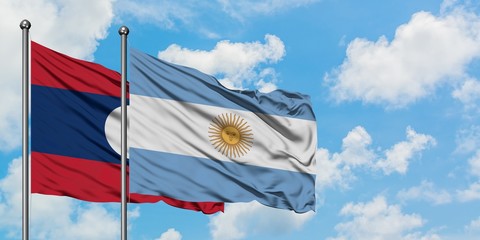 Laos and Argentina flag waving in the wind against white cloudy blue sky together. Diplomacy concept, international relations.