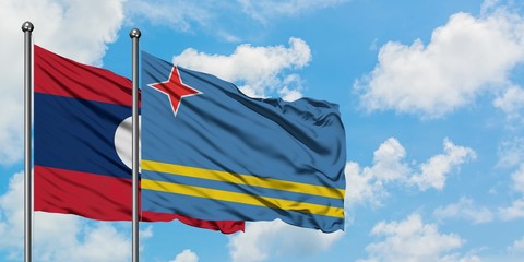 Laos and Aruba flag waving in the wind against white cloudy blue sky together. Diplomacy concept, international relations.