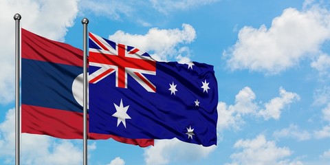 Laos and Australia flag waving in the wind against white cloudy blue sky together. Diplomacy concept, international relations.