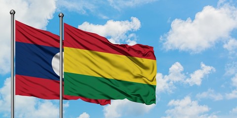 Laos and Bolivia flag waving in the wind against white cloudy blue sky together. Diplomacy concept, international relations.
