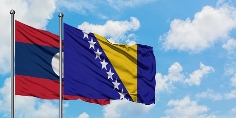 Laos and Bosnia Herzegovina flag waving in the wind against white cloudy blue sky together. Diplomacy concept, international relations.
