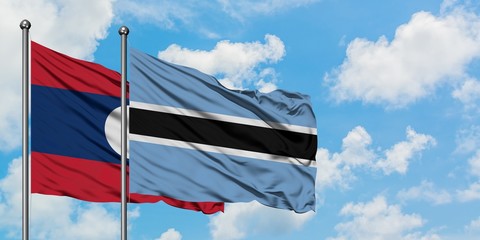 Laos and Botswana flag waving in the wind against white cloudy blue sky together. Diplomacy concept, international relations.