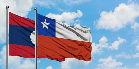 Laos and Chile flag waving in the wind against white cloudy blue sky together. Diplomacy concept, international relations.