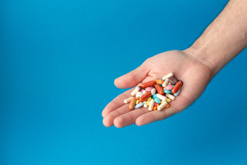 A handful of colored pills on the palm. Medical concept. Shopping at the pharmacy.