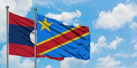Laos and Congo flag waving in the wind against white cloudy blue sky together. Diplomacy concept, international relations.