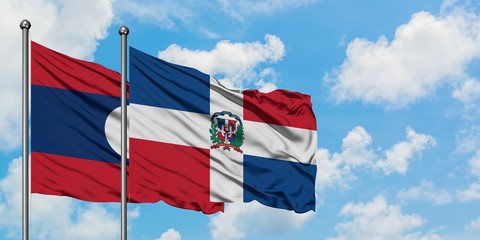 Laos and Dominican Republic flag waving in the wind against white cloudy blue sky together. Diplomacy concept, international relations.