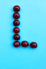 Letter L fresh cherry alphabet blue color flat lay