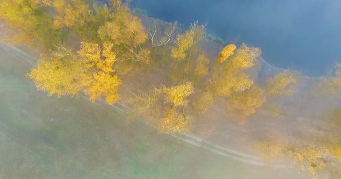 Aerial view of river under morning fog and golden trees, Ukraine