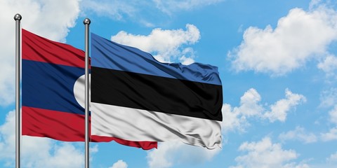 Laos and Estonia flag waving in the wind against white cloudy blue sky together. Diplomacy concept, international relations.