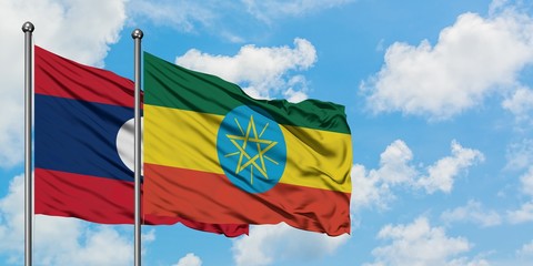 Laos and Ethiopia flag waving in the wind against white cloudy blue sky together. Diplomacy concept, international relations.