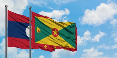 Laos and Grenada flag waving in the wind against white cloudy blue sky together. Diplomacy concept, international relations.