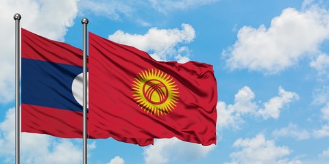 Laos and Kyrgyzstan flag waving in the wind against white cloudy blue sky together. Diplomacy concept, international relations.