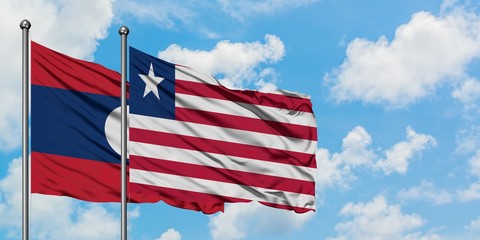 Laos and Liberia flag waving in the wind against white cloudy blue sky together. Diplomacy concept, international relations.