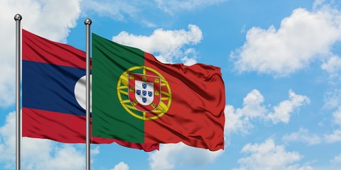 Laos and Portugal flag waving in the wind against white cloudy blue sky together. Diplomacy concept, international relations.