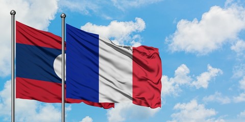 Laos and Reunion flag waving in the wind against white cloudy blue sky together. Diplomacy concept, international relations.