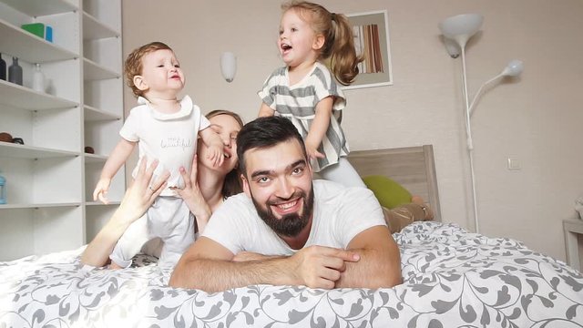 Happy cheerful friendly family lying on the bed. Relationship. close up photo. Love, positive emotion and feeling