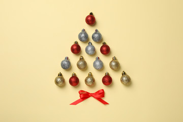 Christmas tree made of baubles on beige background, space for text