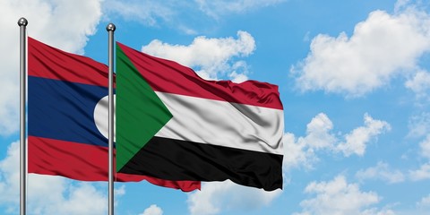 Laos and Sudan flag waving in the wind against white cloudy blue sky together. Diplomacy concept, international relations.