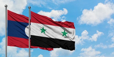 Laos and Syria flag waving in the wind against white cloudy blue sky together. Diplomacy concept, international relations.