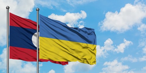 Laos and Ukraine flag waving in the wind against white cloudy blue sky together. Diplomacy concept, international relations.