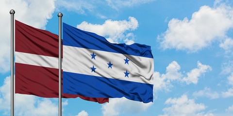 Latvia and Honduras flag waving in the wind against white cloudy blue sky together. Diplomacy concept, international relations.