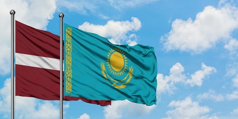Latvia and Kazakhstan flag waving in the wind against white cloudy blue sky together. Diplomacy concept, international relations.