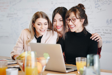Candid moment, three young beautiful female coworkers talking to boss over video call in the...