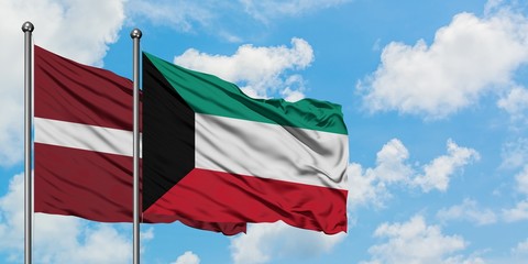 Latvia and Kuwait flag waving in the wind against white cloudy blue sky together. Diplomacy concept, international relations.