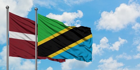 Latvia and Tanzania flag waving in the wind against white cloudy blue sky together. Diplomacy concept, international relations.