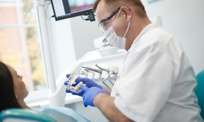 Doctor dentist treats teeth of a beautiful young girl patient. The girl on reception at the dentist. Doctor dentist treats tooth