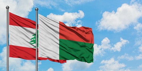 Lebanon and Madagascar flag waving in the wind against white cloudy blue sky together. Diplomacy concept, international relations.