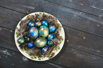 Fototapeta na wymiar Painted colored Easter eggs on animal skin in plate on dark wooden background. Boho stile.