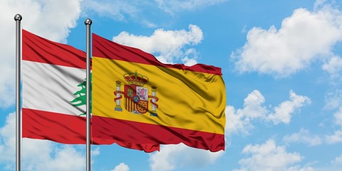 Lebanon and Spain flag waving in the wind against white cloudy blue sky together. Diplomacy concept, international relations.
