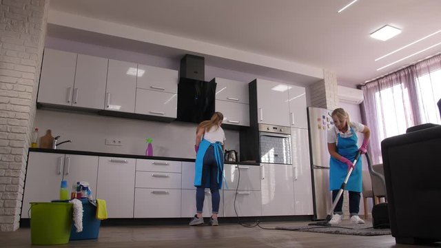 Time lapse of home cleaning services, cleaning ladies mopping floor, vacuuming carpet, washing sink, wiping kitchen surfaces in apartment. Skillful employees of cleaning company during work
