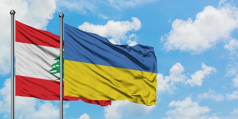 Lebanon and Ukraine flag waving in the wind against white cloudy blue sky together. Diplomacy concept, international relations.
