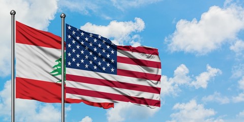Lebanon and United States flag waving in the wind against white cloudy blue sky together. Diplomacy concept, international relations.