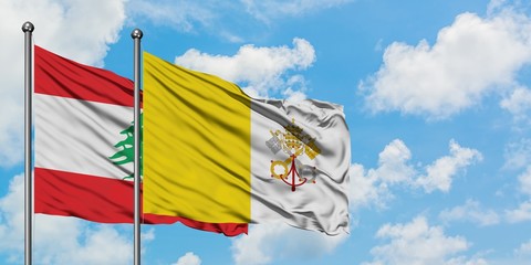 Lebanon and Vatican City flag waving in the wind against white cloudy blue sky together. Diplomacy...