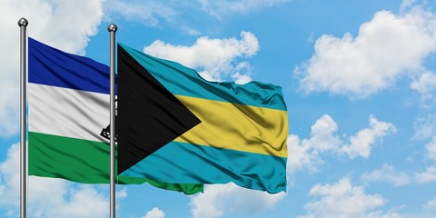 Lesotho and Bahamas flag waving in the wind against white cloudy blue sky together. Diplomacy concept, international relations.