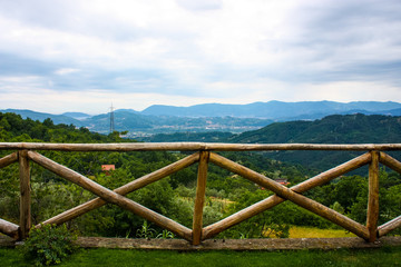 panoramic view of the mountains of liguria behind a wooden fence during a cloudy day