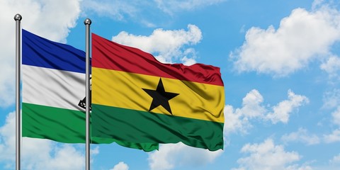 Lesotho and Ghana flag waving in the wind against white cloudy blue sky together. Diplomacy concept, international relations.