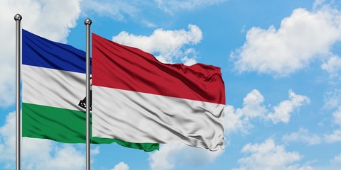 Lesotho and Indonesia flag waving in the wind against white cloudy blue sky together. Diplomacy concept, international relations.