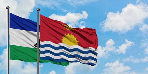Lesotho and Kiribati flag waving in the wind against white cloudy blue sky together. Diplomacy concept, international relations.